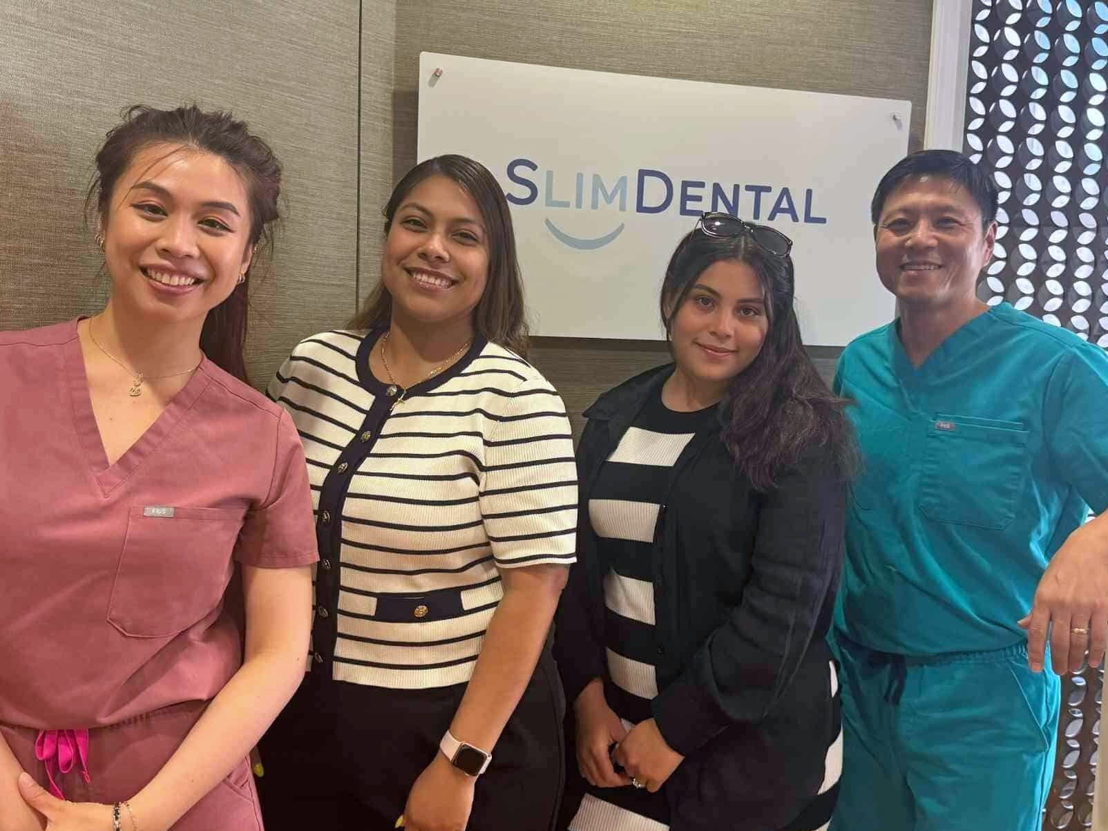 The Slim Dental team at their Manhattan office, in front of the Slim Dental sign